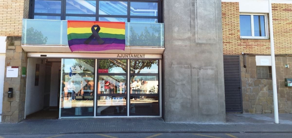 Bandera gai amb el crespó negre a la façana de l'Ajuntament