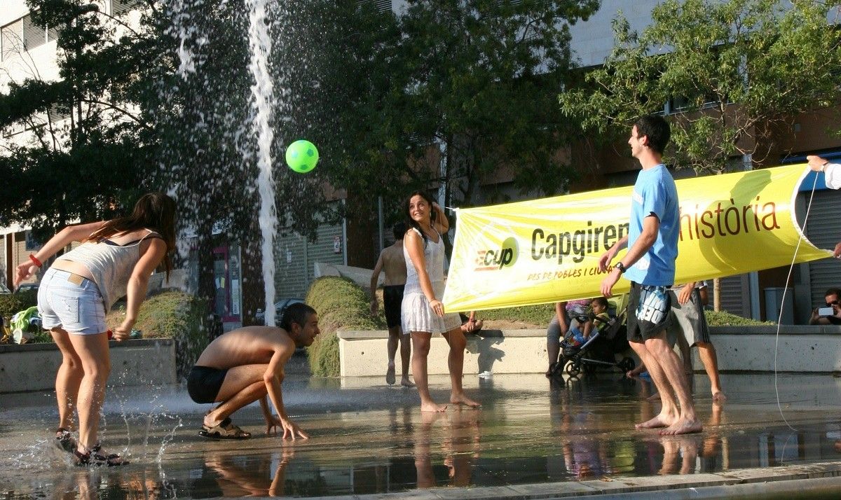 Els 'cupaires' juguen a voleibol a la font de la plaça de Ricard Camí.