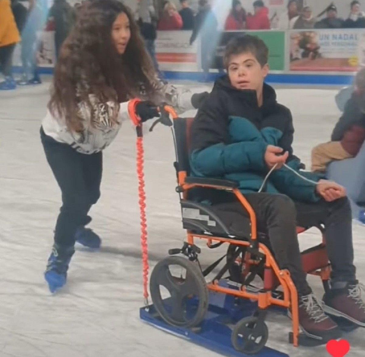 La nena ajudant a patinar al seu germà amb capacitats diverses, gravat per l'actriu Toni Acosta 