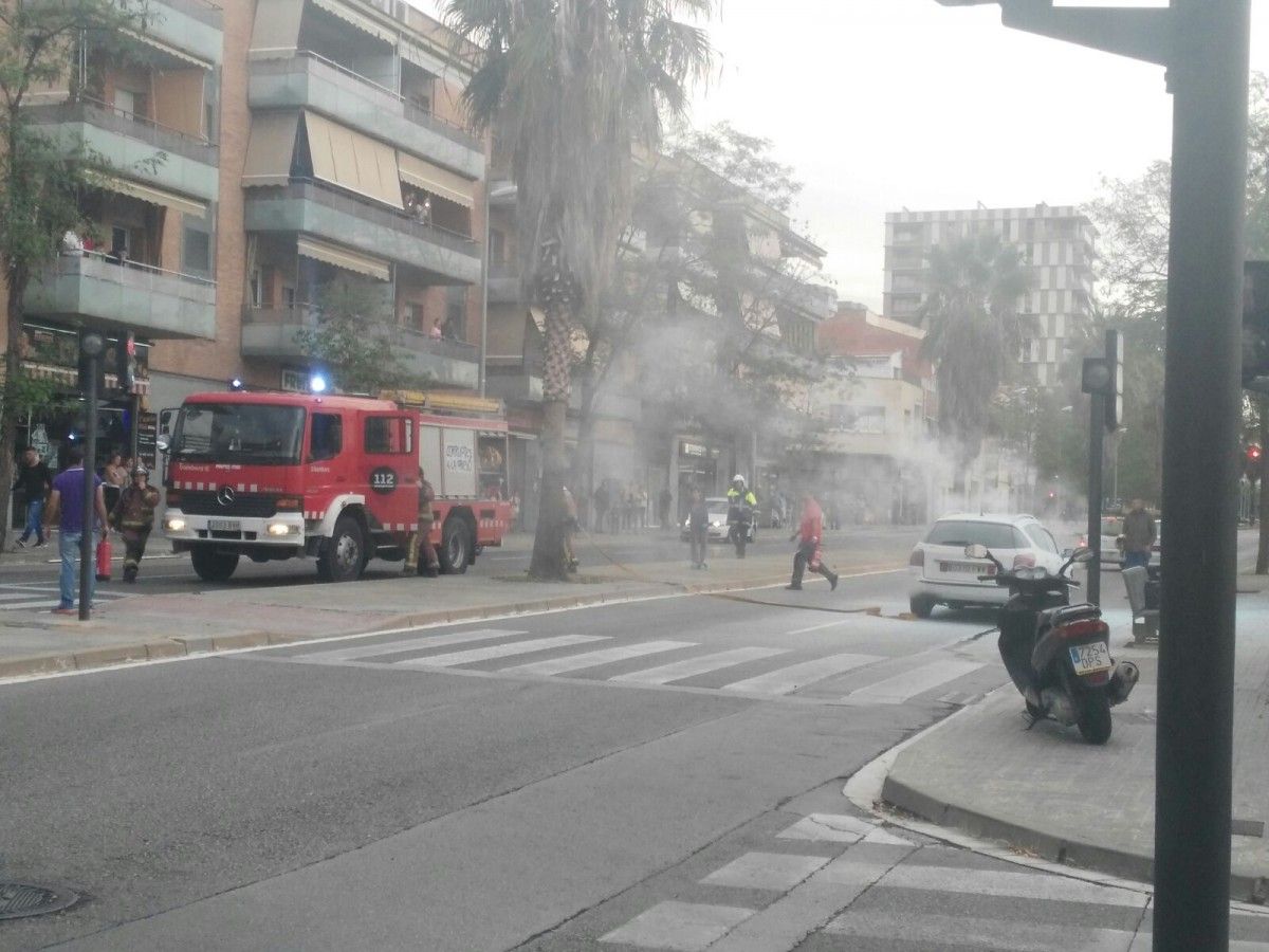 Els Bombers, apagant el cotxe que ha cremat a l'avinguda de Béjar de Terrassa