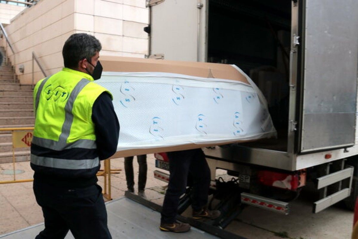 Els operaris de l'empresa de transport carregant al Museu de Lleida una de les peces d'art de la Franja dins del camió