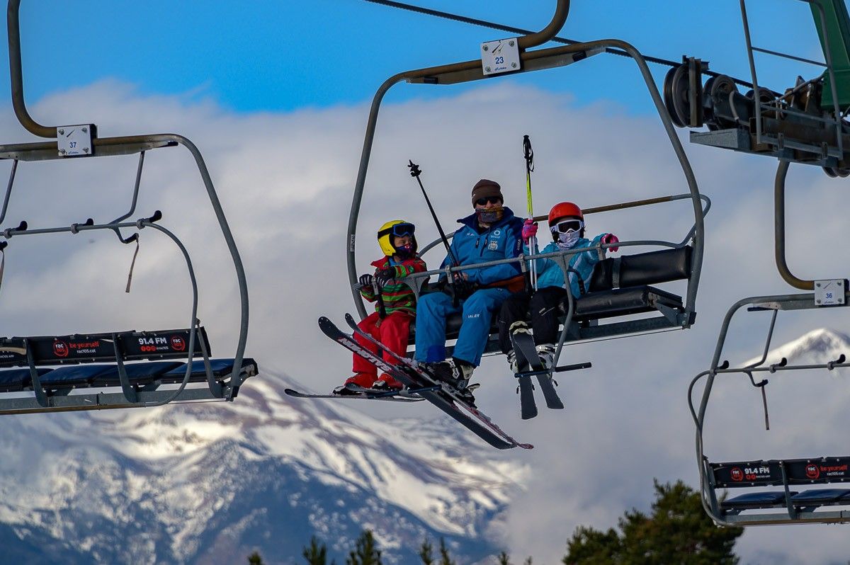 Tres esquiadors en un telecadira