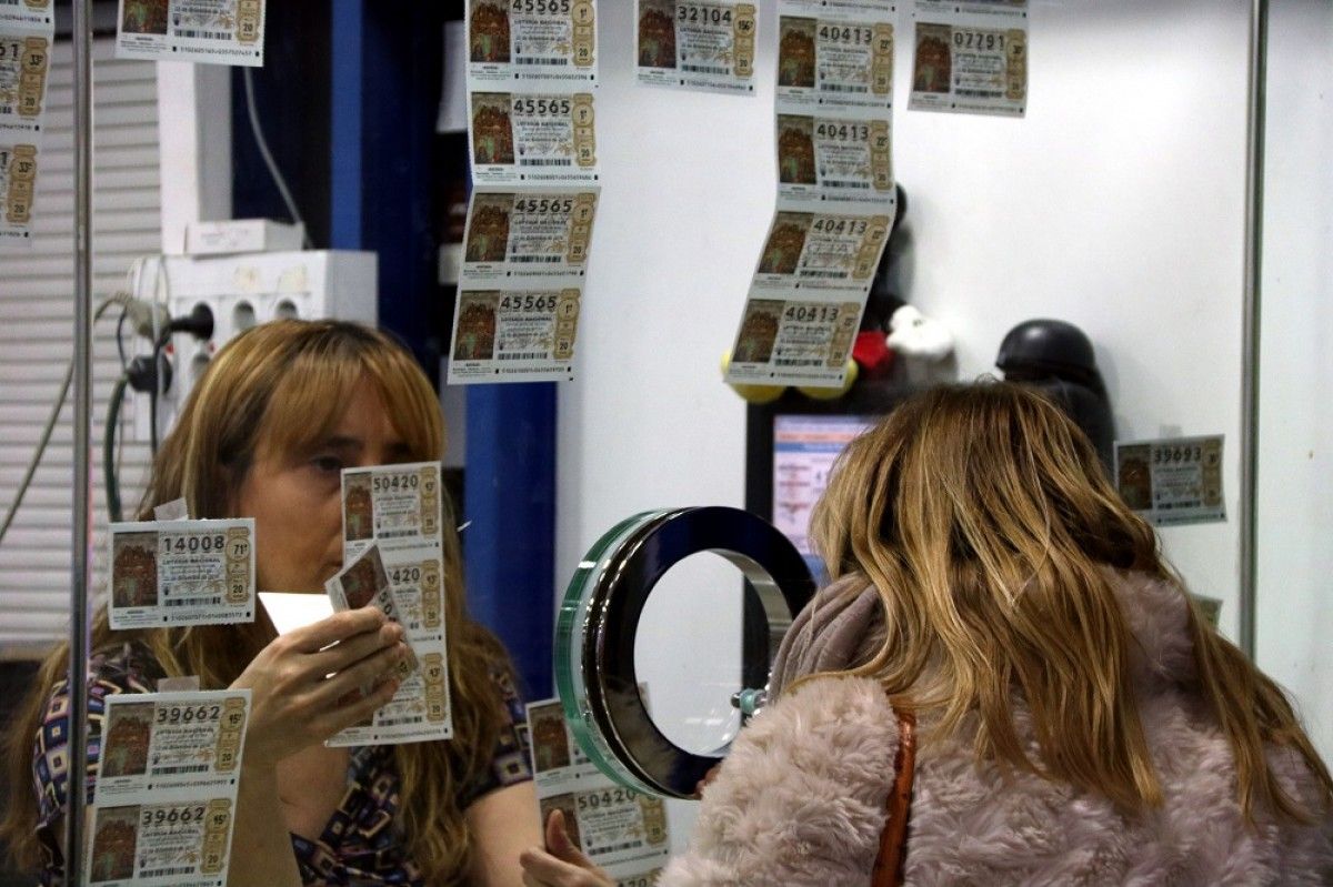 Una clienta compra un dècim de loteria aquest matí en una administració de Tarragona.