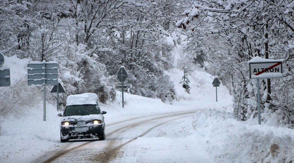 Un vehicle cobert de neu circula amb dificultats en una carretera del Pallars Sobirà