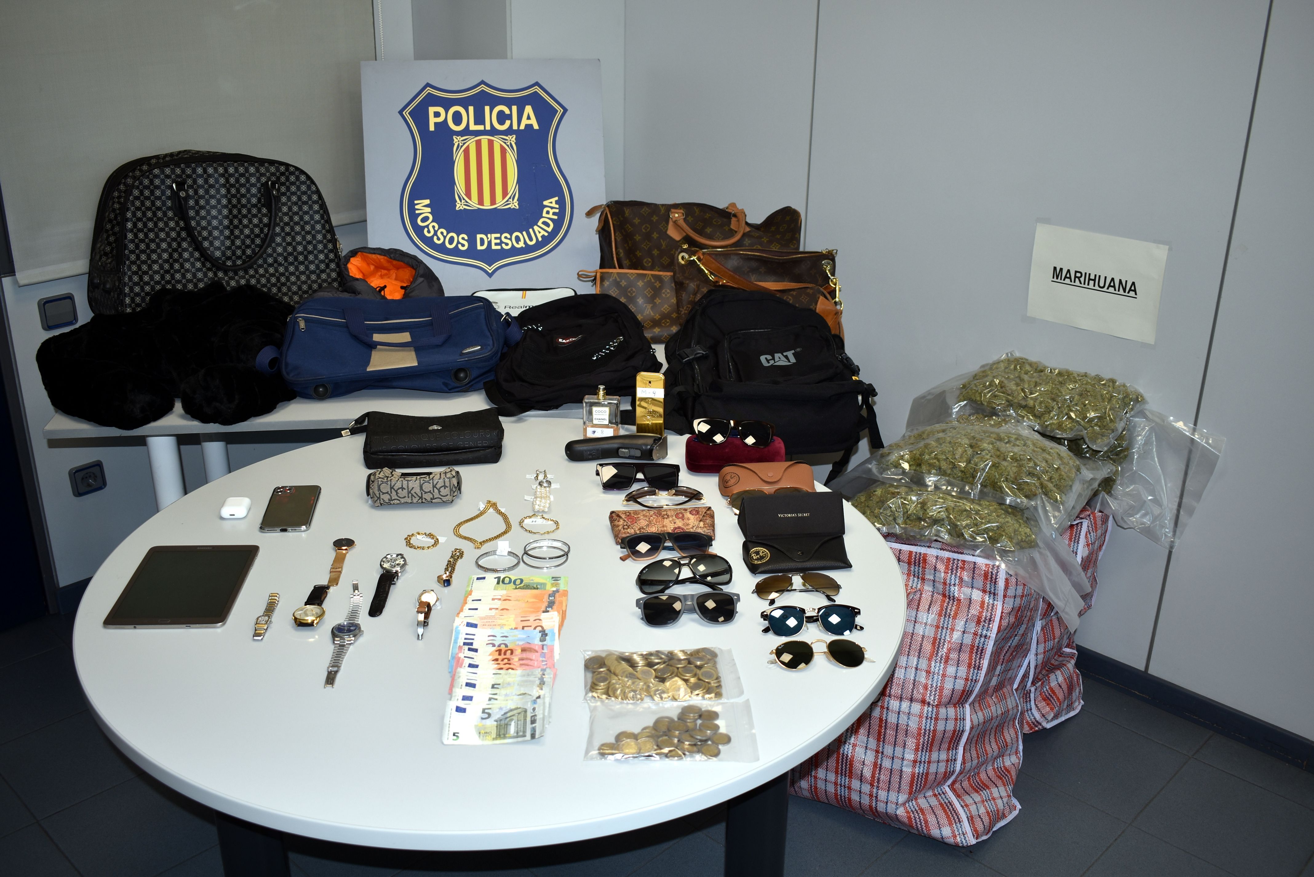 Els 13 quilos de marihuana envasada al buit, joies, rellotges, roba i diners decomissats del grup criminal