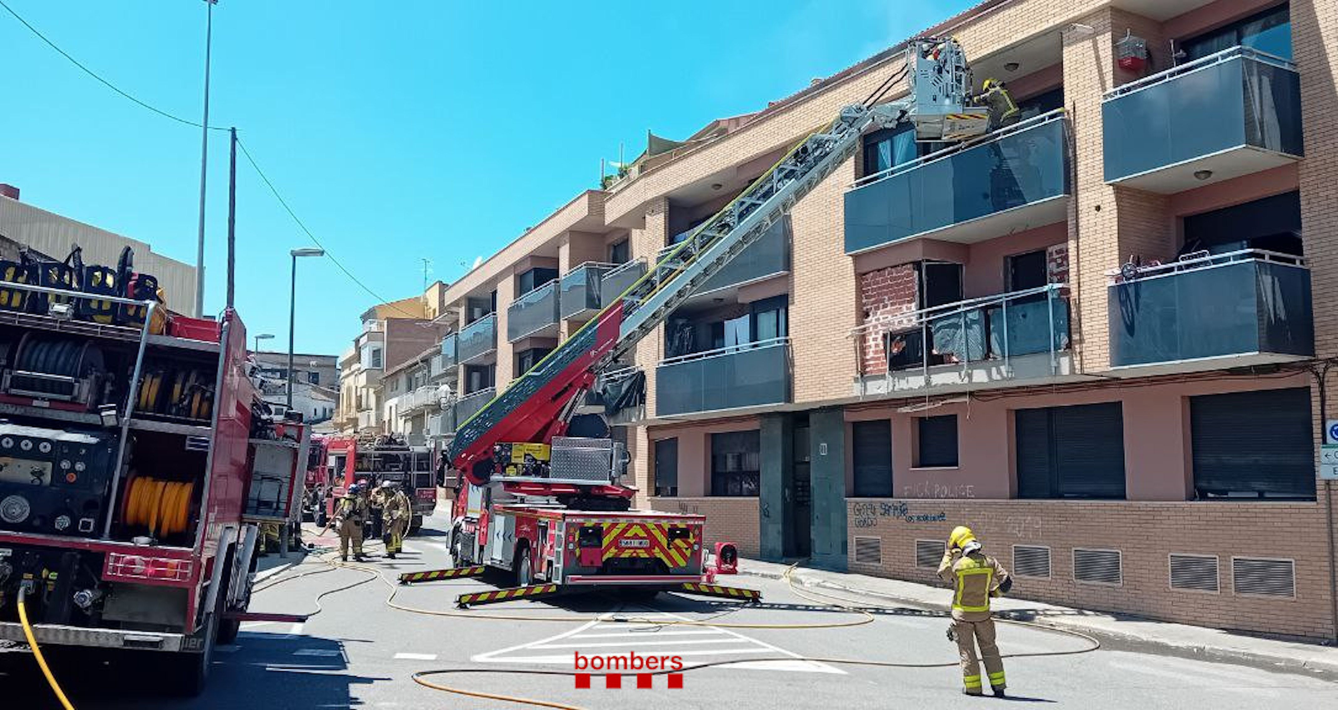 Bombers treballant al bloc afectat per l'incendi