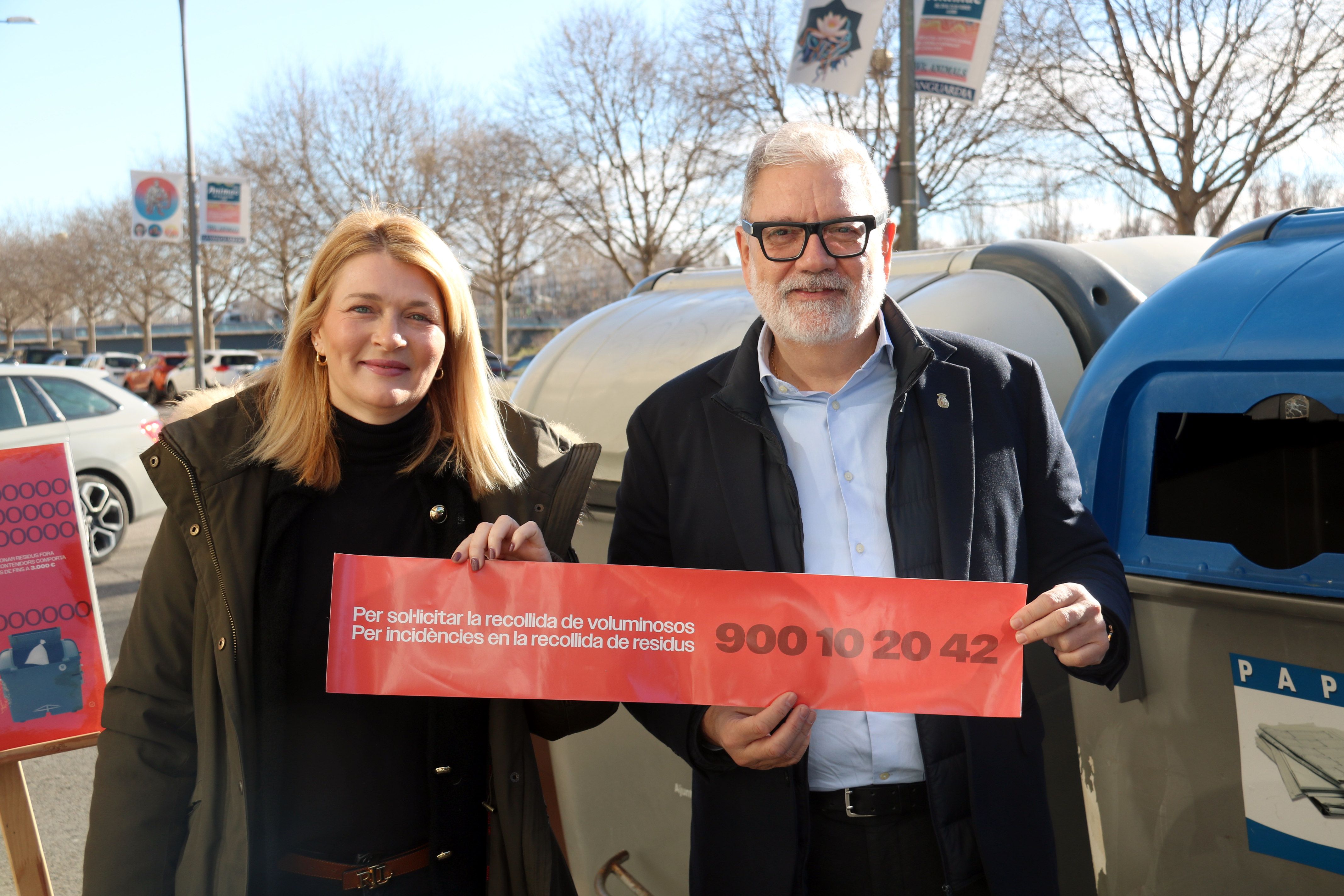 L'alcalde de Lleida, Fèlix Larrosa, i la tinenta d'alcalde Begoña Iglesias mostren un cartell amb el número de telèfon del servei gratuït de recollida de residus voluminosos