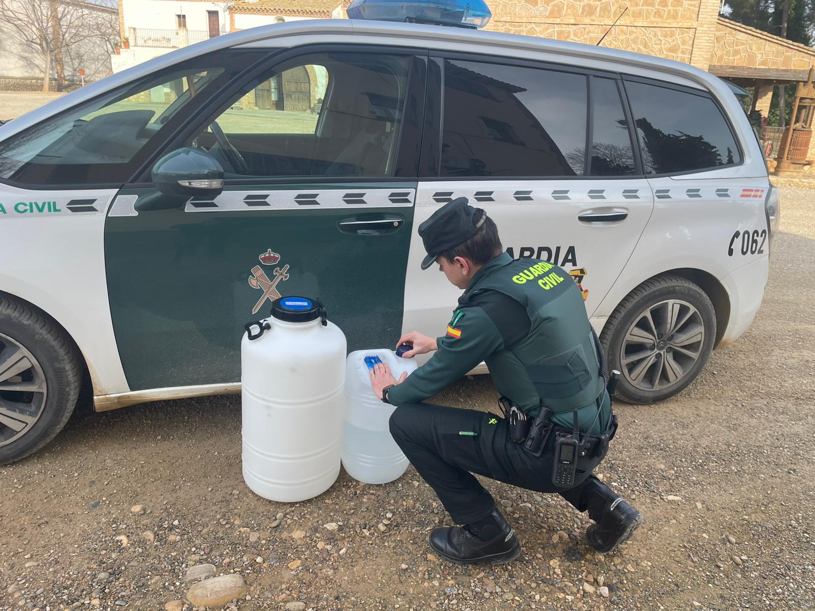 Un agent de la policia espanyola observa dos bidons en el marc d'una operació contra el robatori de productes fitosanitaris