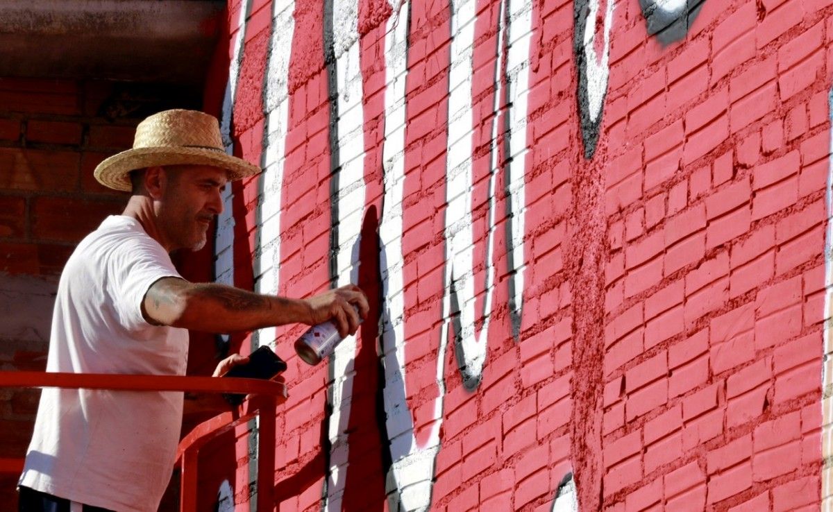 Un artista fent un mural 