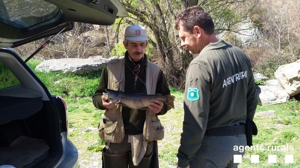Un Agent Rural inspeccionant un pescador al riu Noguera Pallaresa.
