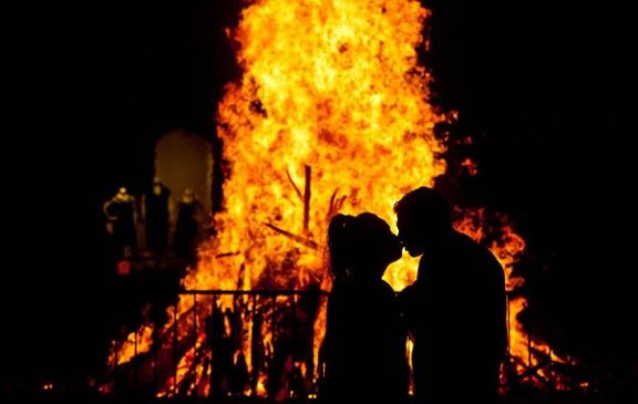 Una parella fent-se un petó davant la foguera de la plaça Major de Vic.