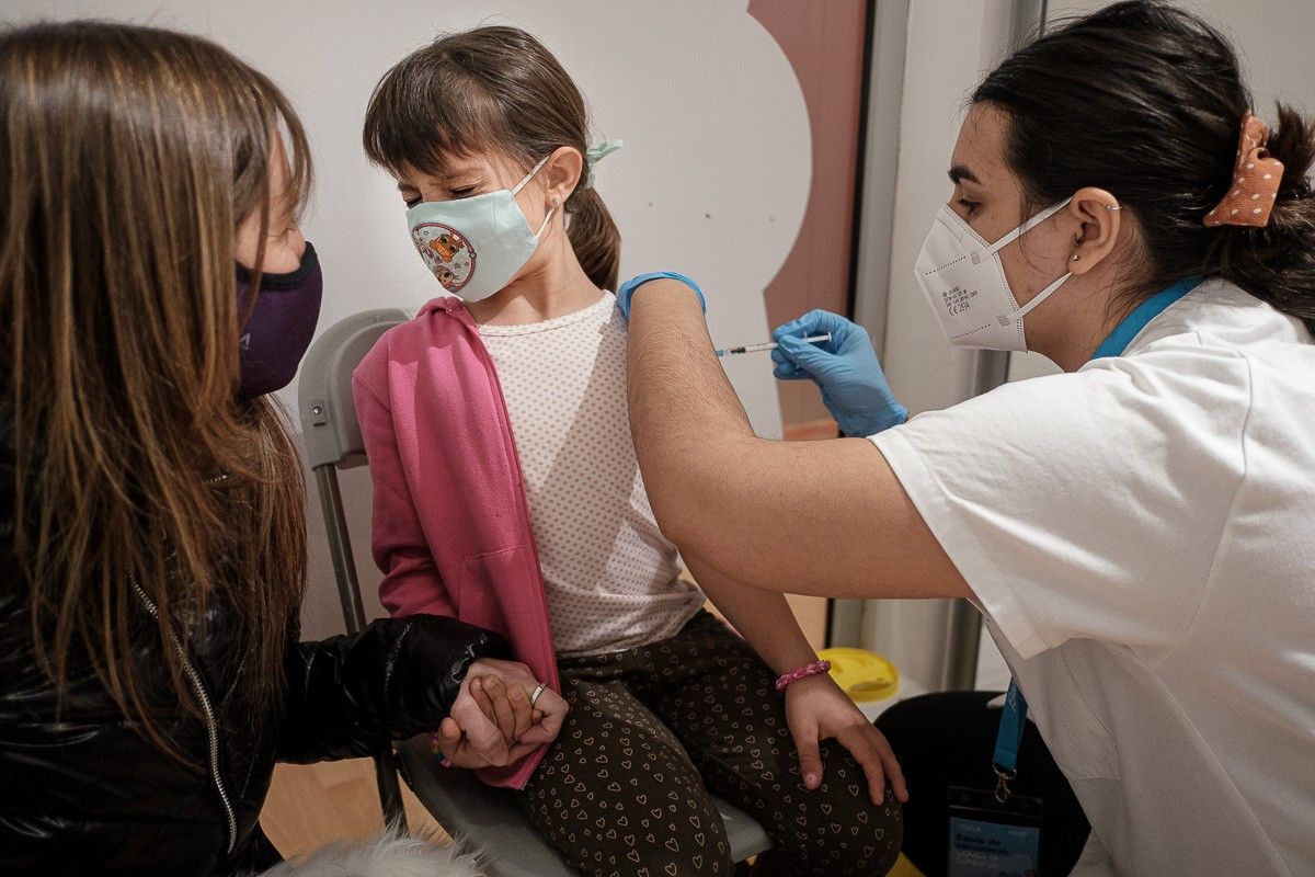 Una sanitària vacunant una nena