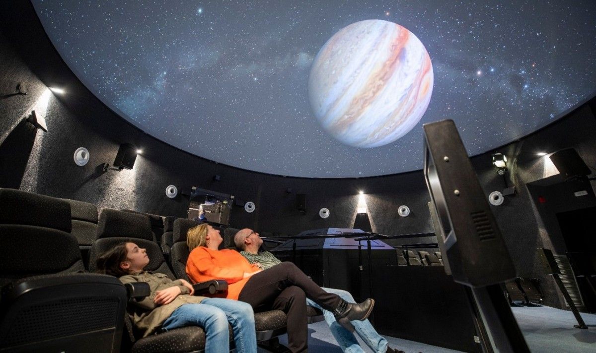 Tres visitants gaudeixen de la projecció d'una pel·lícula al planetari del Parc Astronòmic del Montsec (PAM) d'Àger, en una imatge d'arxiu.