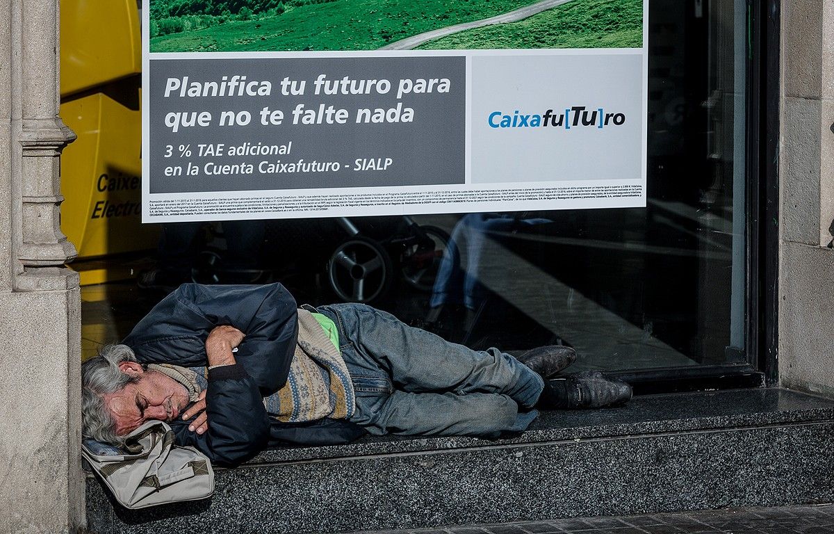 Un home dormint a l'exterior d'una entitat bancària