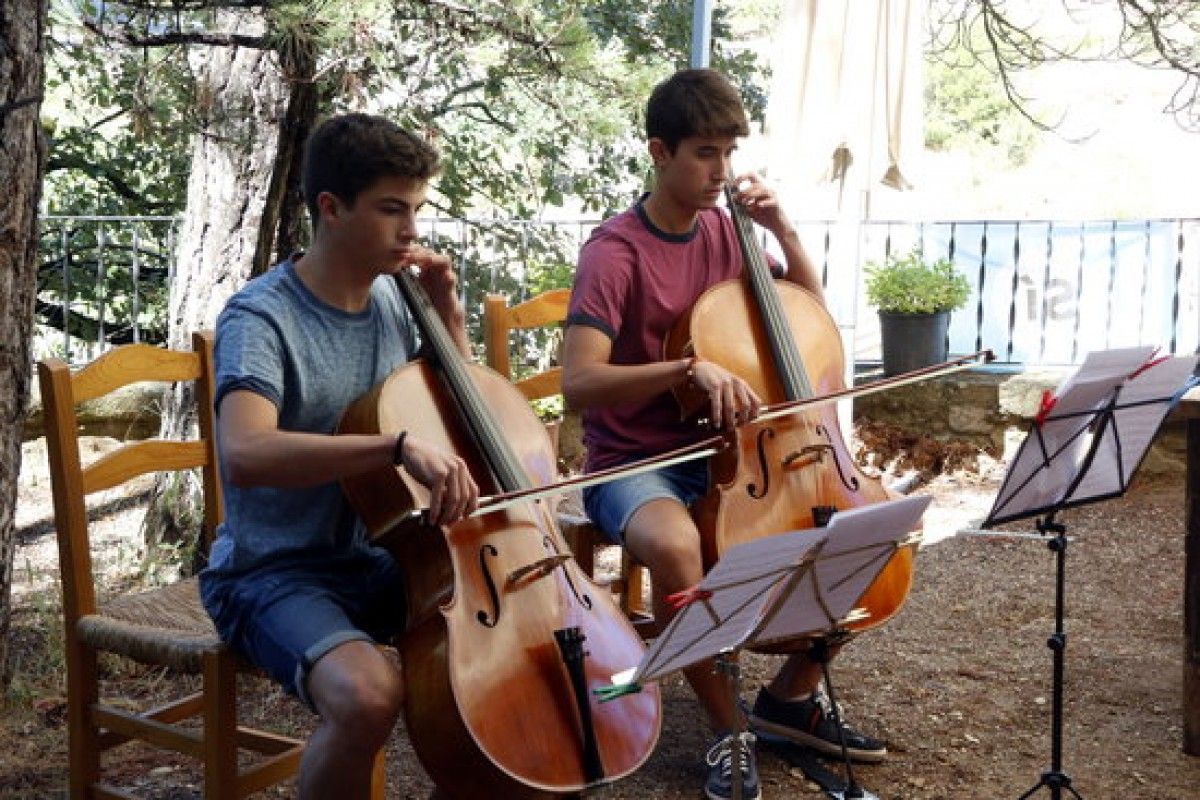 En Jorge Forés i en Gerard Flotats, dos alumnes de l'AIMS, oferint un concert a casa d'una persona gran