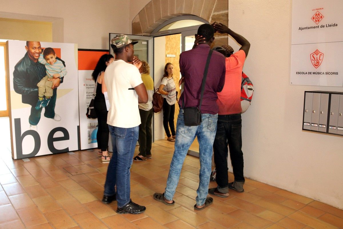 Un grup de temporers esperant per inscriure's a l'oficina d'atenció social ubicada a l'antic convent de Santa Clara de Lleida