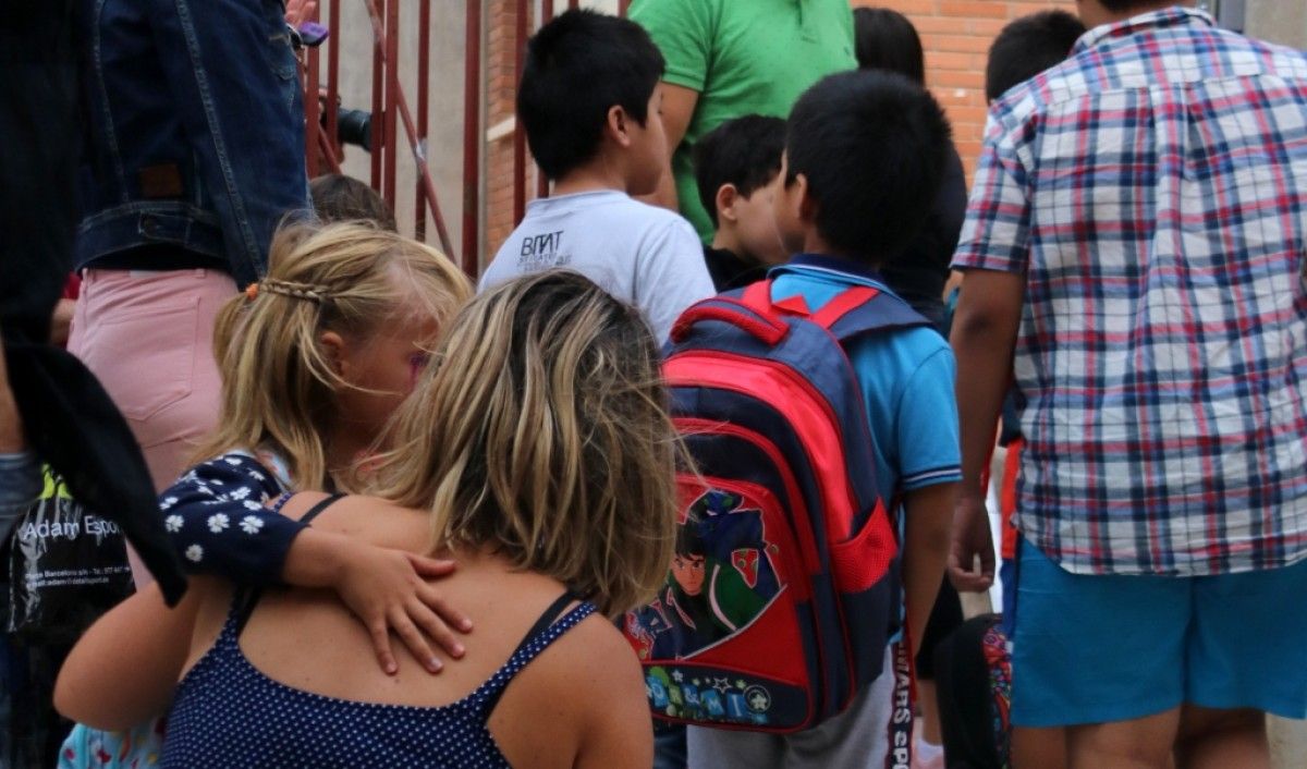 Imatge d'alumnes petits a les portes d'una escola
