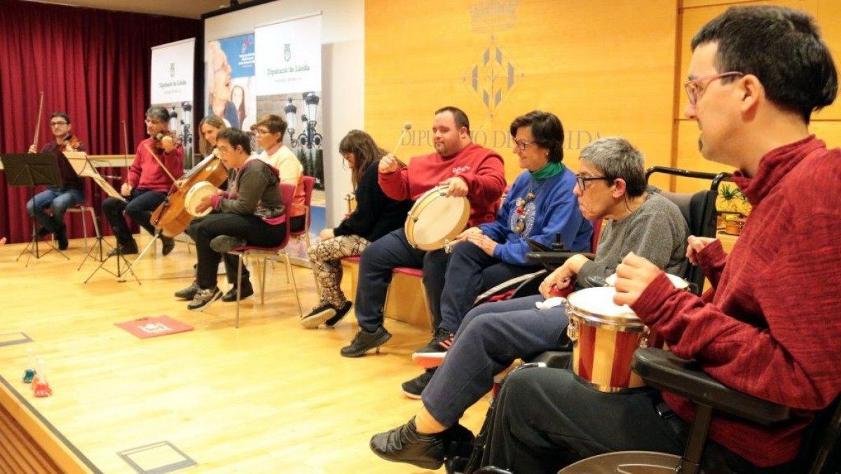 Usuaris del centre Espígol de Cervera tocant amb músics de l'Orquestra Julià Carbonell 