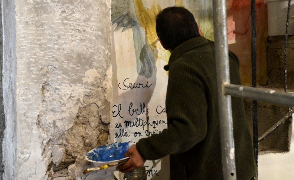 Santi Moix pintant a un dels laterals de l'església de Saurí.