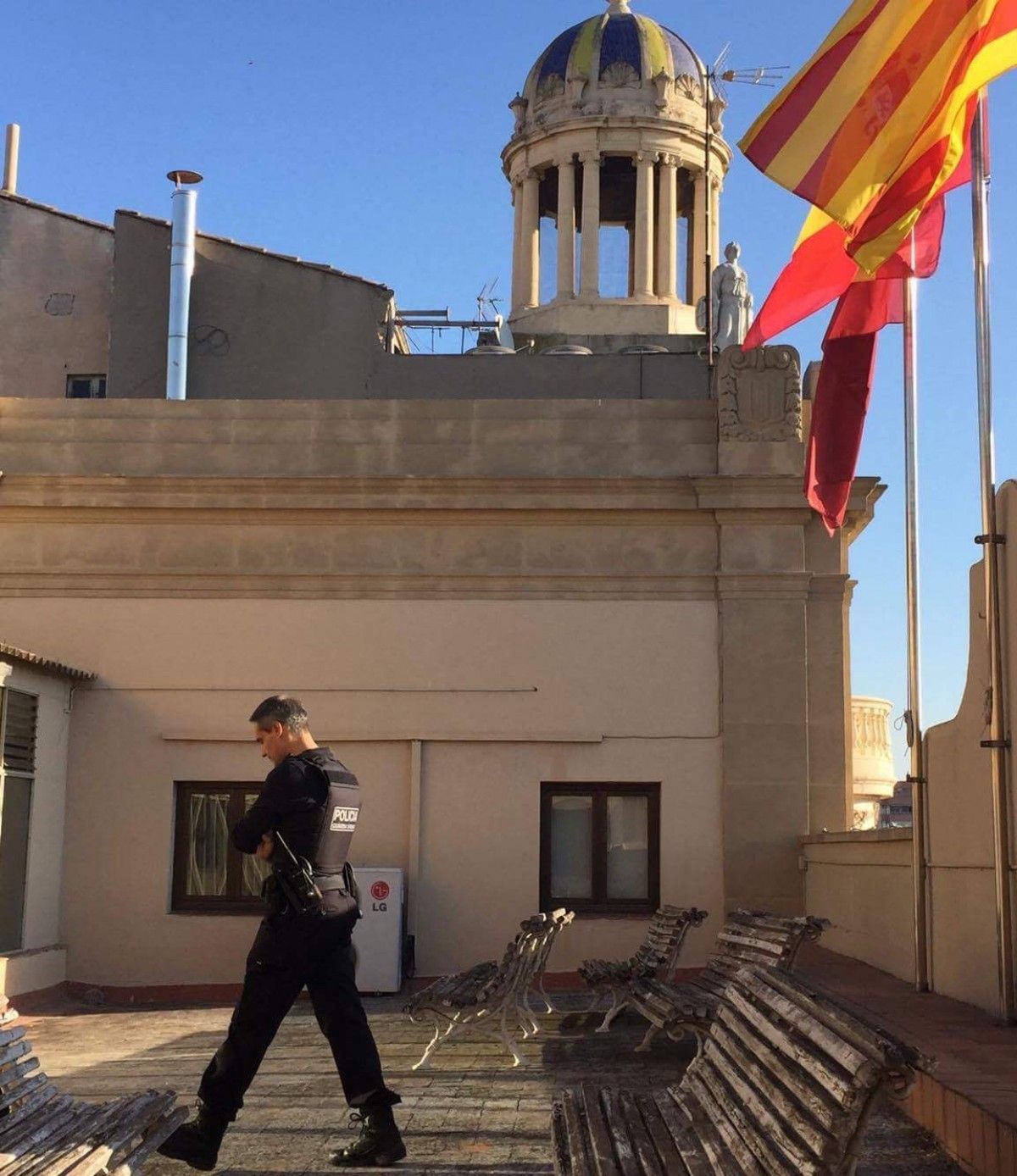 Un dels agents vigilant la bandera espanyola