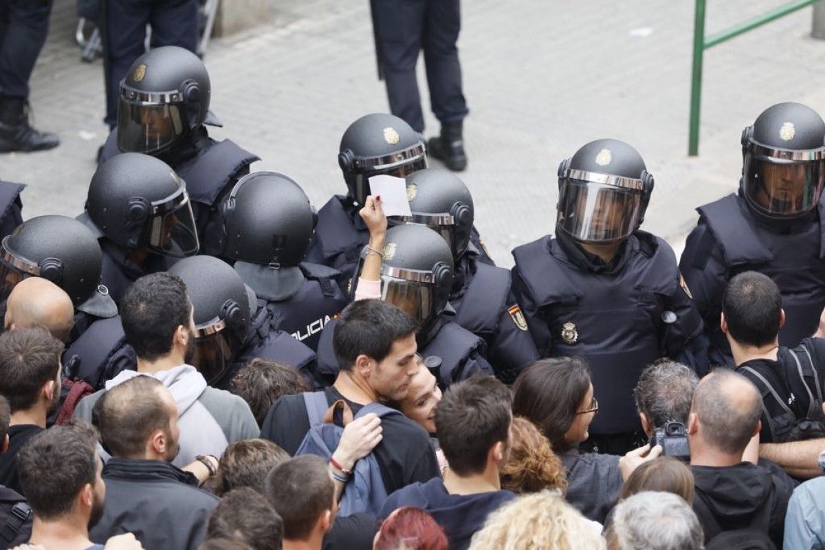 La Policia Nacional encerclant la gent per treure les urnes