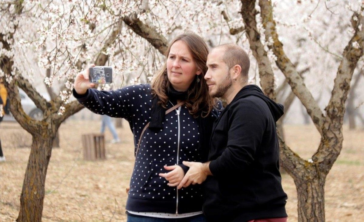 Una parella fent-se un selfie al davant d'un ametller