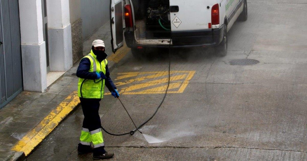 Un treballador desinfectant un carrer de Mollerussa