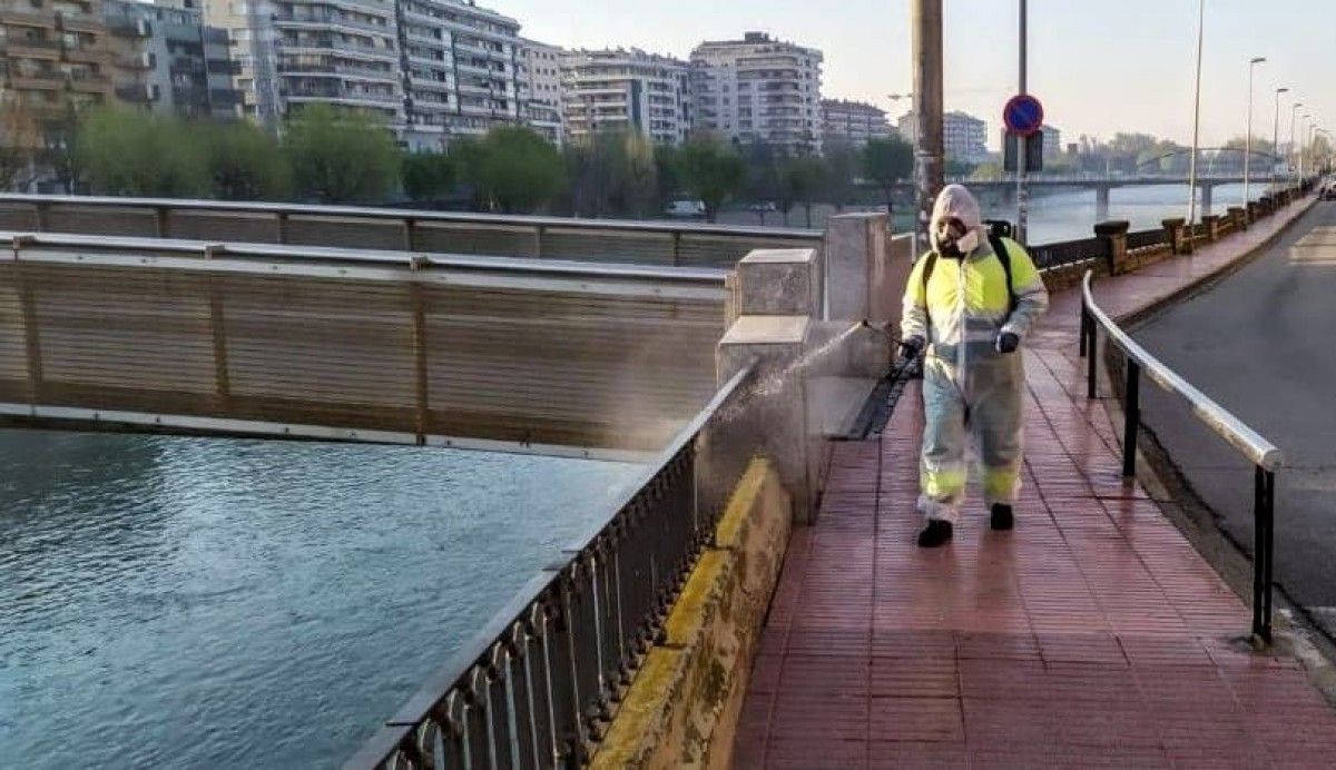 Un treballadors desinfectant les baranes del riu