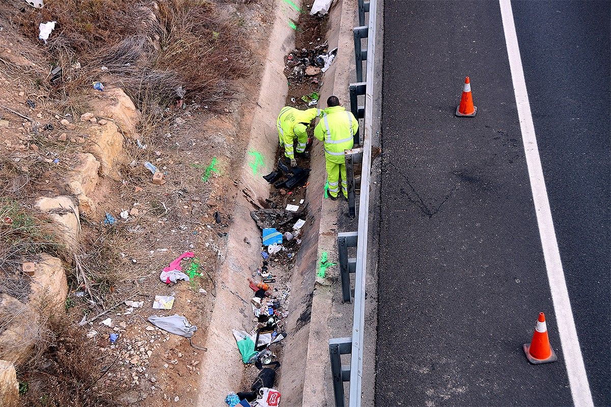 Dos operaris recollint les restes del vehicle accidentat a Tarragona