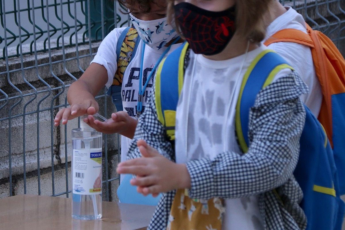 Una nena, en imatge d'arxiu, es neteja les mans abans d'entrar a escola
