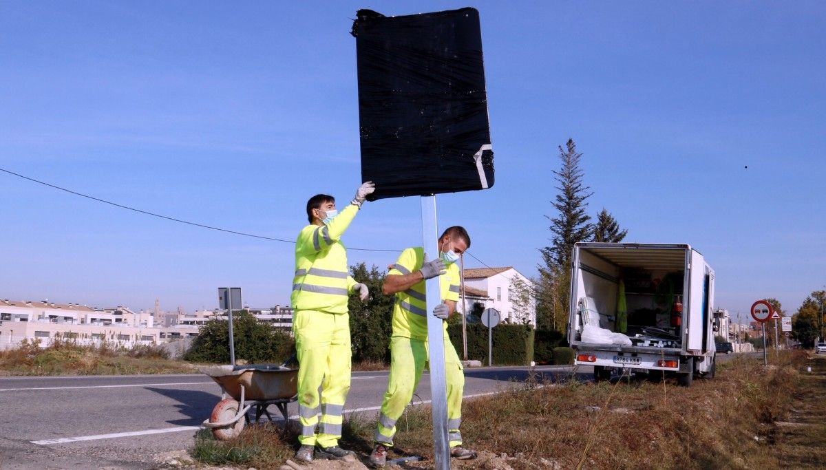 Dos operaris col·locant un senyal a Lleida