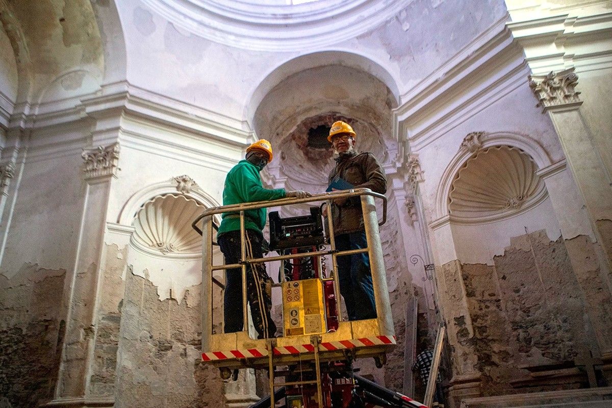 Dos operaris que treballen en la restauració de les capelles barroques del convent de Sant Domènec de Cervera.