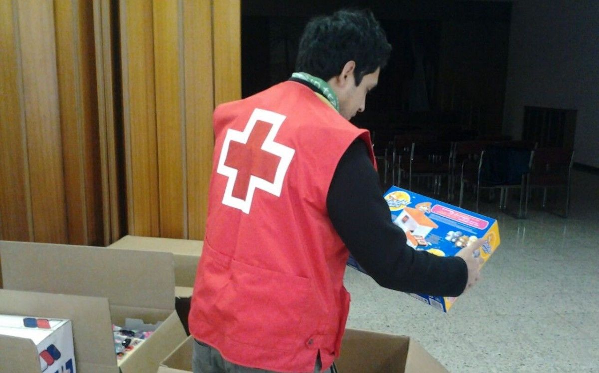 Un voluntari de Creu Roja Manresa classificant els regals per la Campanya de Joguines