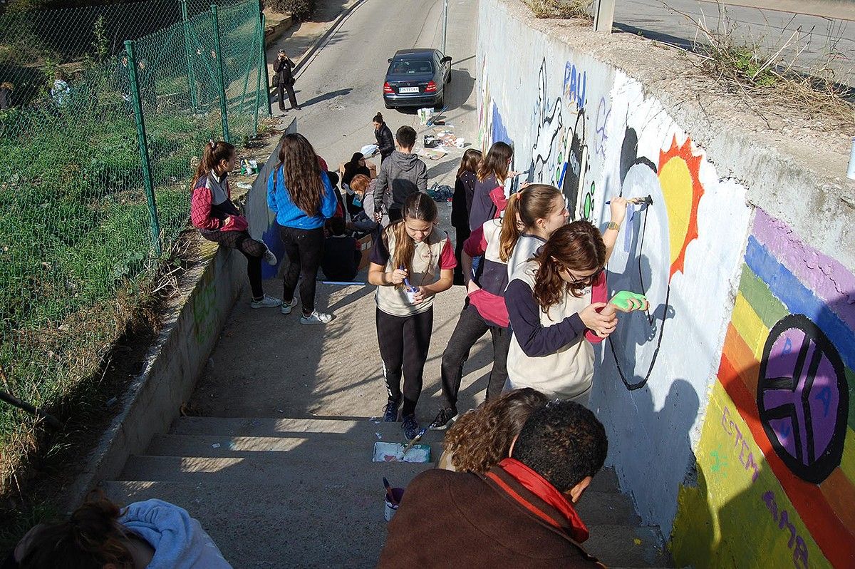 Joves pintant el mural per la pau