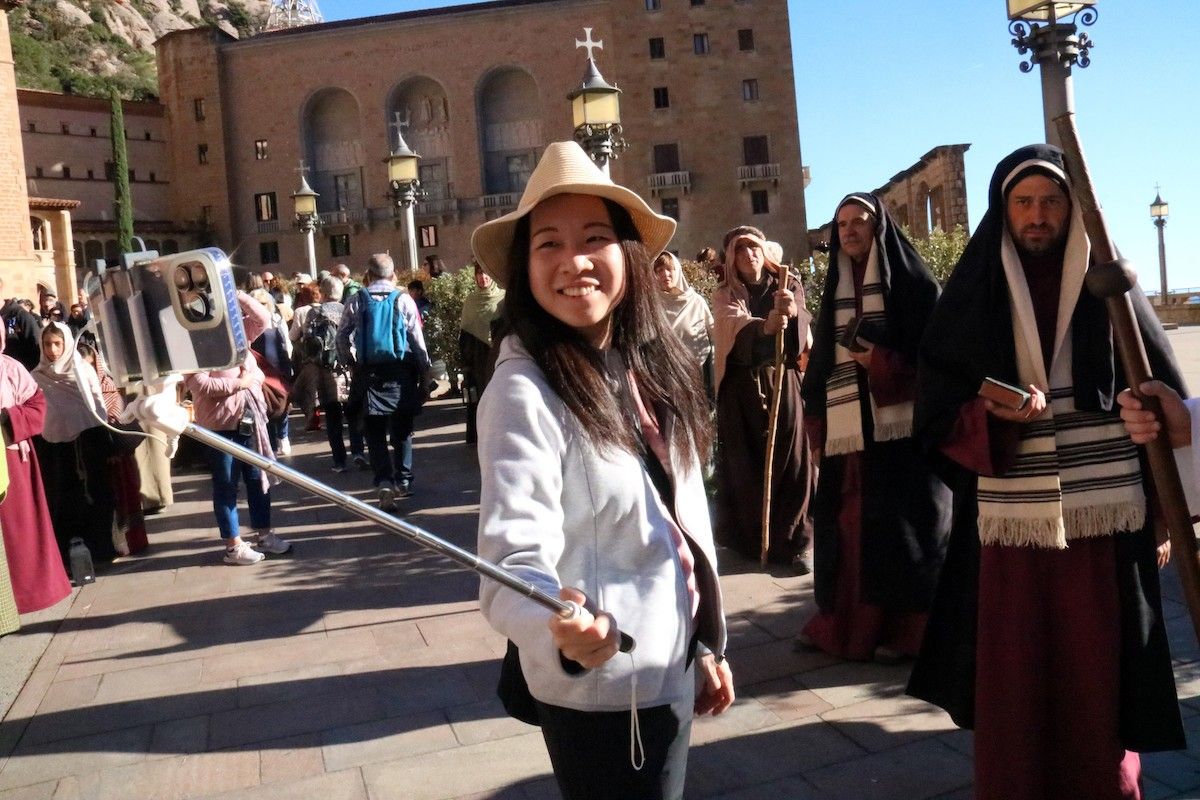 Una turista es fa una foto amb els figurants del pessebre vivent gegant de Montserrat