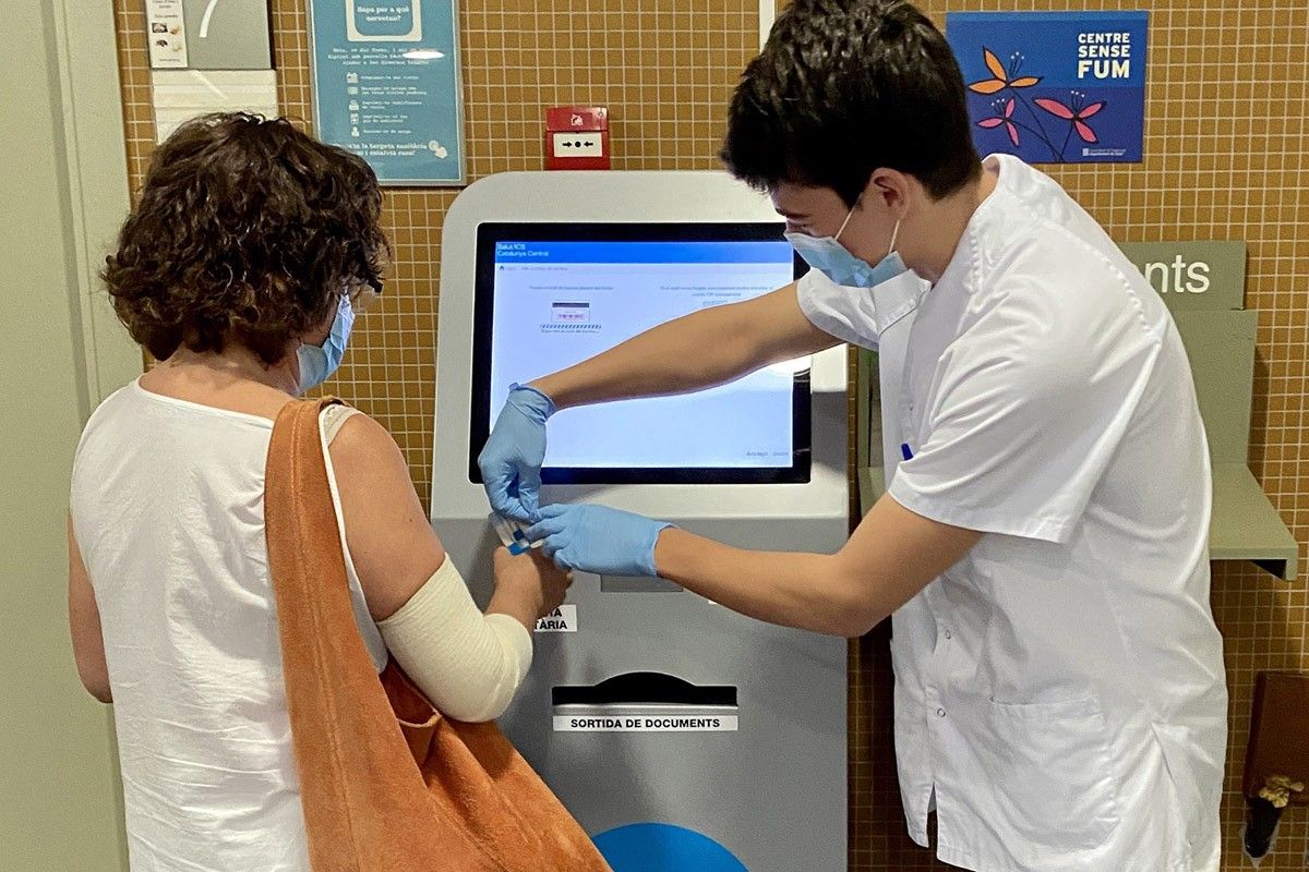 Una professional de l'ICS mostra a una pacient el funcionament de la pantalla