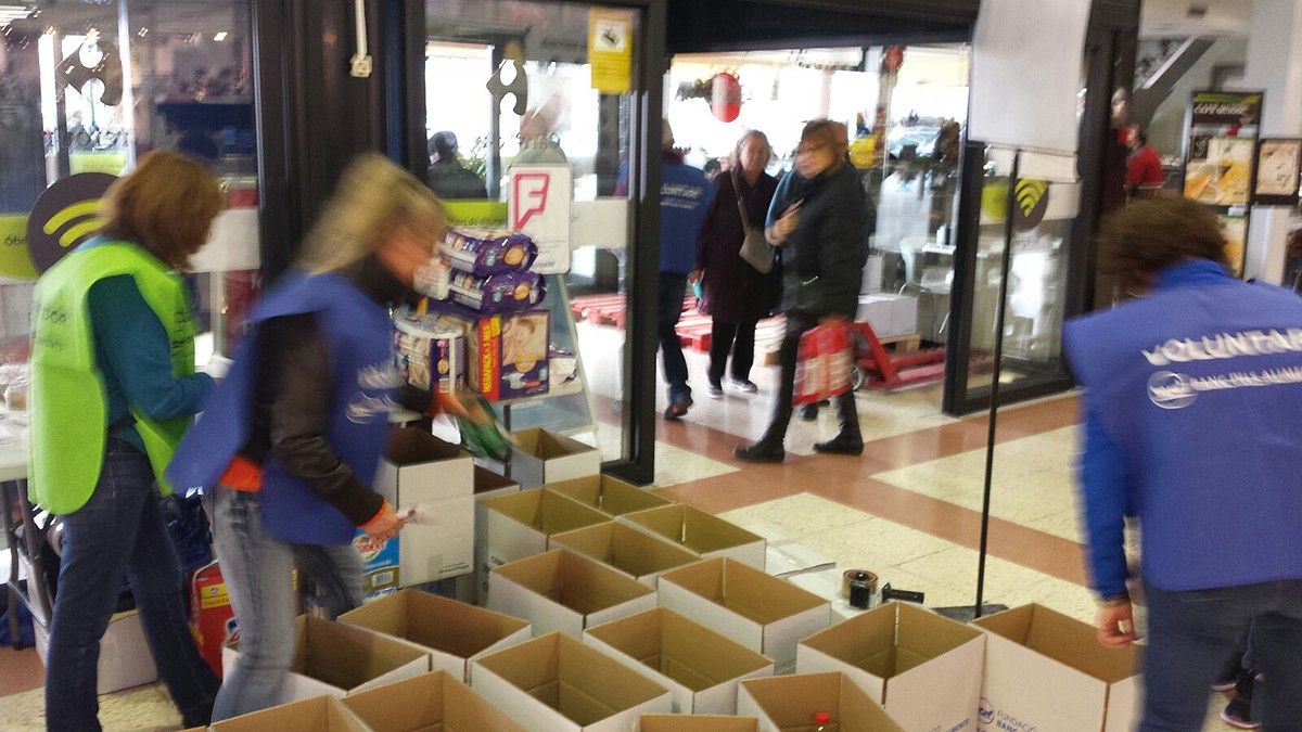 Voluntaris classificant els productes a mesura que arriben en un supermercat de Manresa
