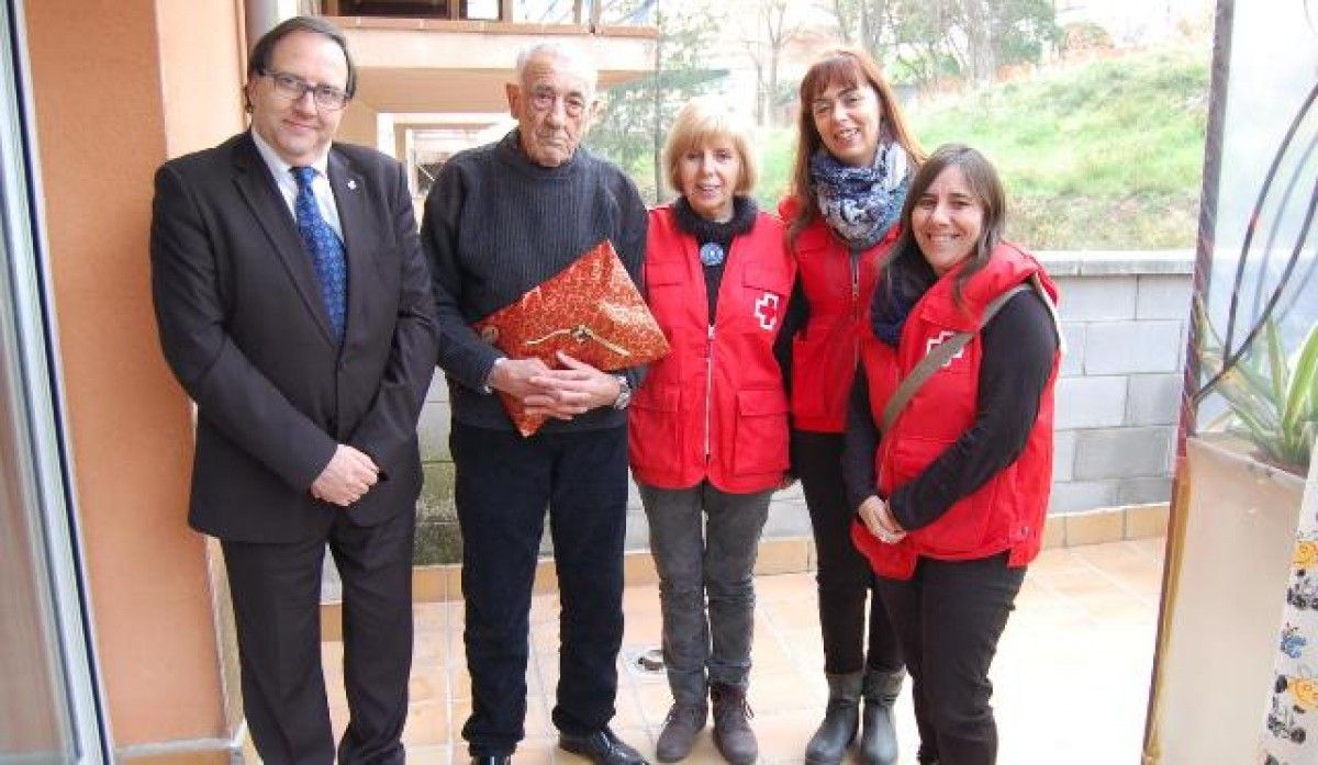 Miquel Davins i volntaris de la Creu Roja repartint regals als avis necessitats.