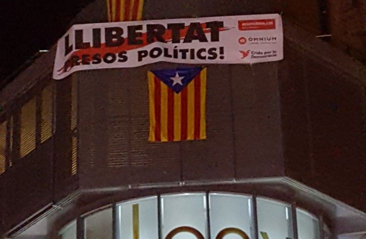 Pancarta de «Llibertat presos polítics» a l'últim pis de l'edifici on està situada la botiga Tous