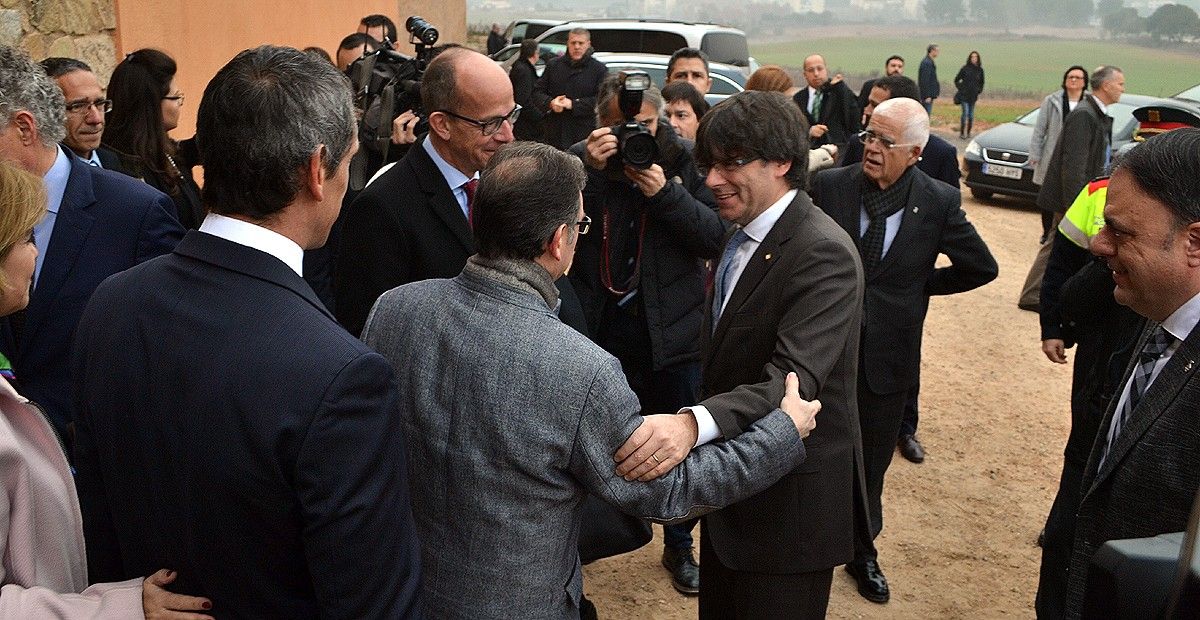 Carles Puigdemont, a la seva arribada a l'Oller del Mas, saluda Jaume Giró, de l'OS la Caixa, i Jordi Cardoner, de la Fundació FCB