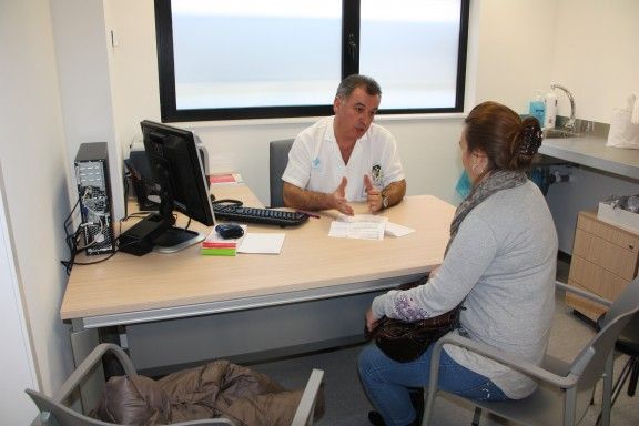 Un metge atenent una consulta en una imatge d'arxiu