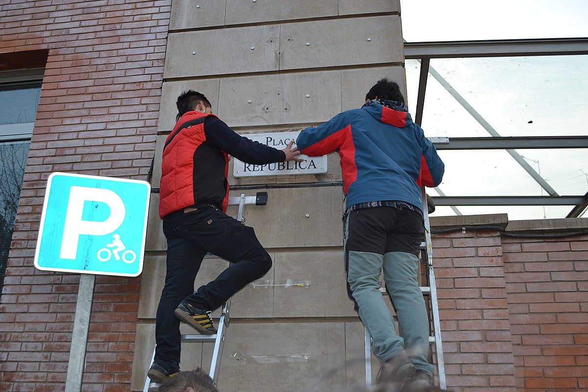 Dos activistes acaben d'instal·lar la placa de plaça de la República