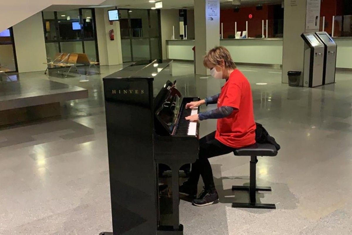 Carme Botifoll tocant el piano al vestíbul de l'hospital Sant Joan de Déu