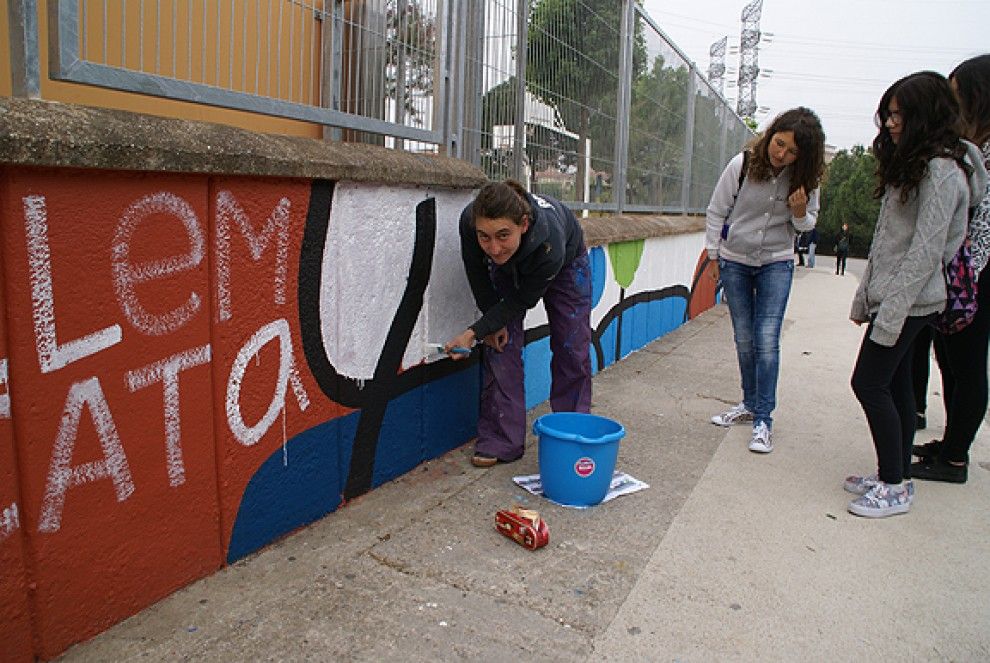 Susanna Ayala pinta un mural a la paret exterior de l'Institut Guillem Catà.
