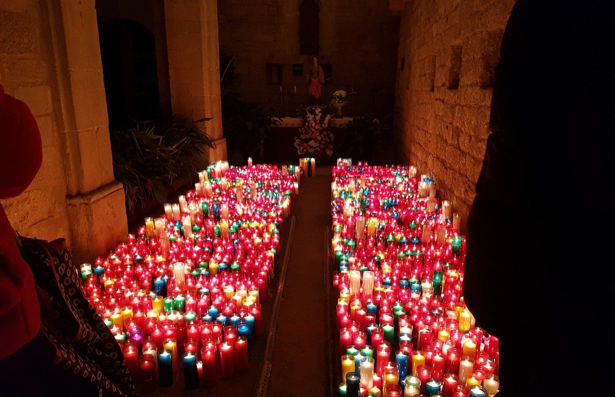 Espelmes als peus de Santa Llúcia