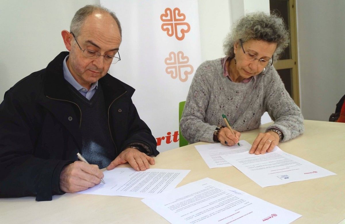 Antoni Garriga, d'Elèctrica Garriga, i Fina Farrés, de Càritas, durant la signatura del conveni