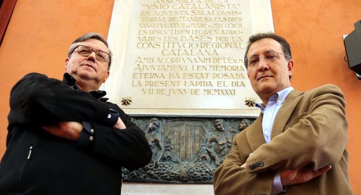 Els comissaris Francesc Comas i Jordi Rodó davant la placa commemorativa de Les Bases de Manresa