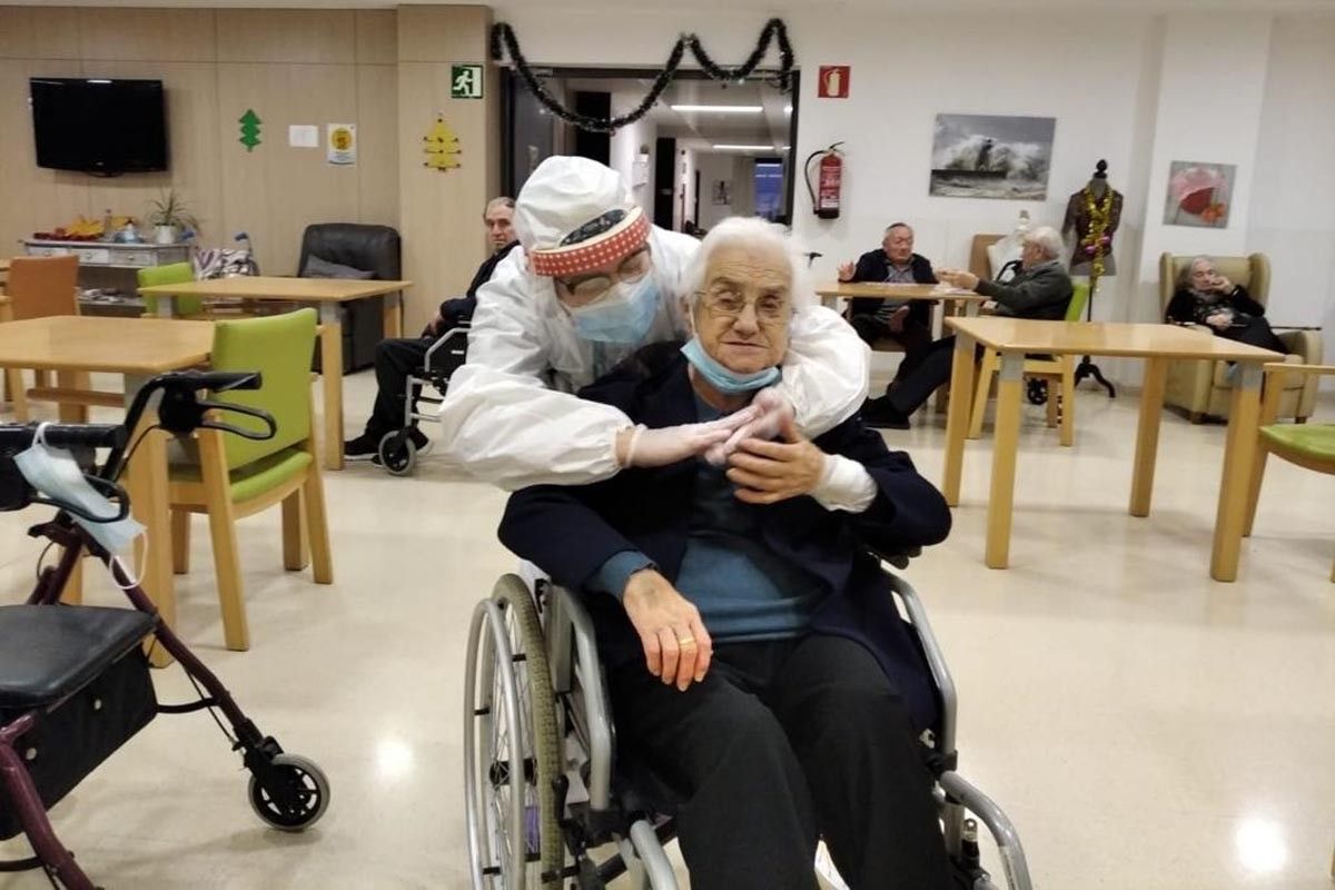 Una assistenta de la residència abraça una usuària acabada d'arribar de l'hospital