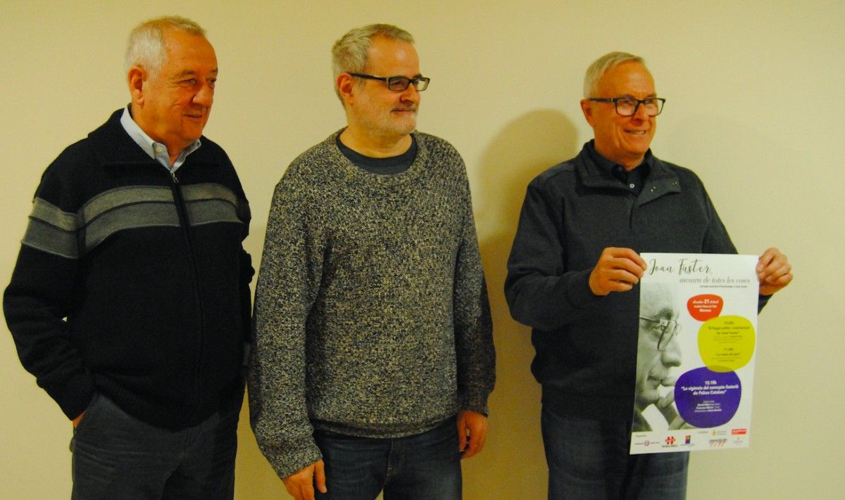 Josep Heras, Jordi Torra i Robert Martí, membres del Col·lectiu Desvalls, ensenyant el cartell de clausura de l'Any Fuster