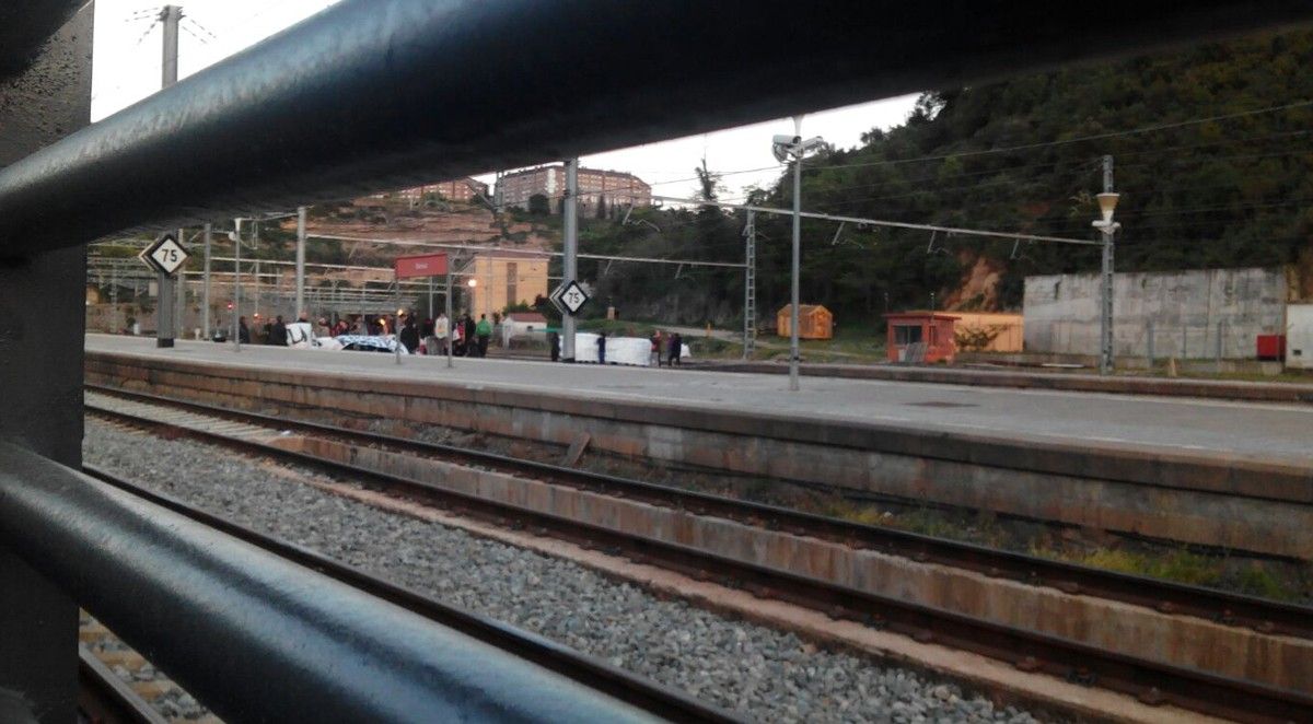 Manifestants, al fons, tallant la via del tren a l'estació de la Renfe de Manresa